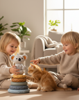 Two children playing with a toy and a cat in a cozy living room.
